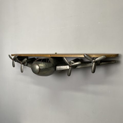 A wooden shelf rest on the wings of a metal plane