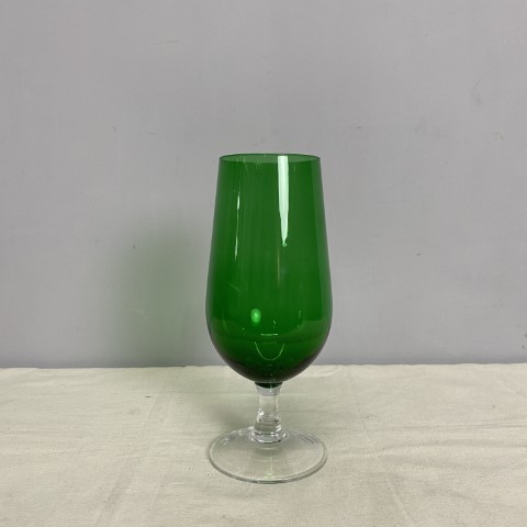 A deep green art glass chalice with clear glass stem and base.