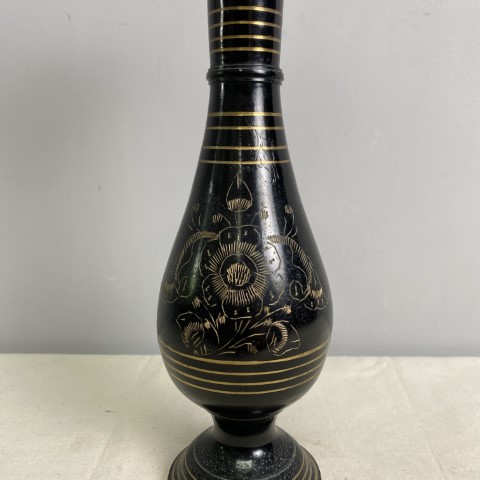 a black brass vase with etched decoration