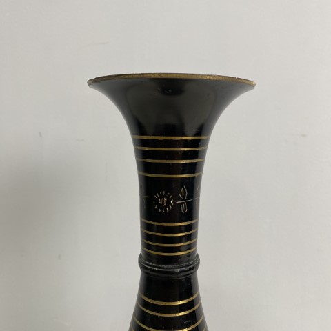 a black brass vase with etched decoration