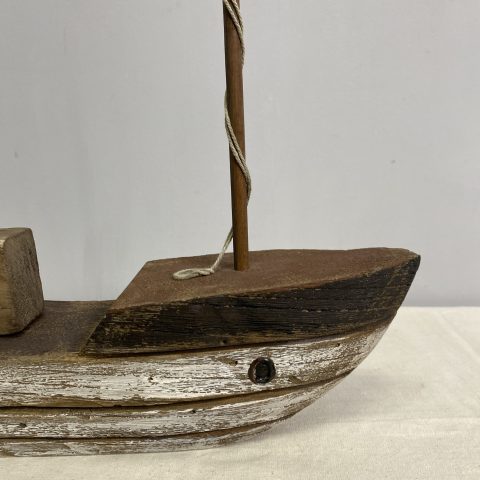 A decorative rustic sailing boat with three masts without sails made from reclaimed wood.