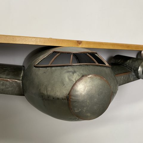 A wooden shelf rest on the wings of a metal plane