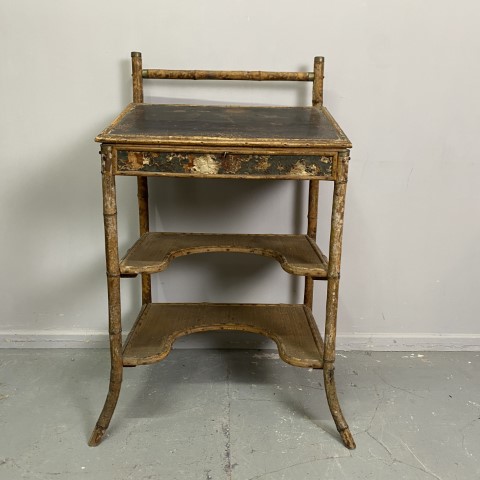 An antique standing height desk with tilted, lift-up desk top. It is constructed with bamboo and has painted details on the panels. It has 2 shelfs below the desktop with an arched cut out space.