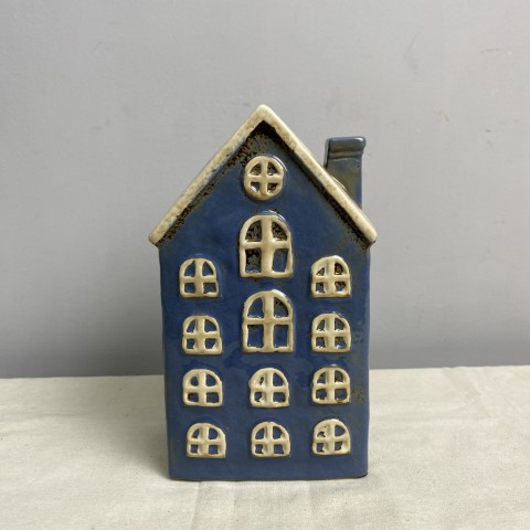 A ceramic vase or planter in the shape of a blue house with a white roof