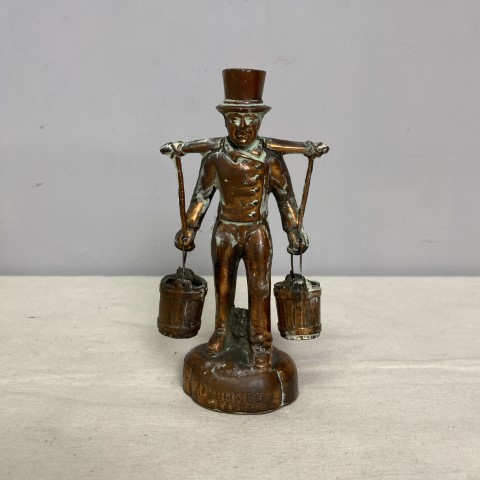A small copper figurine of a man holding 2 buckets