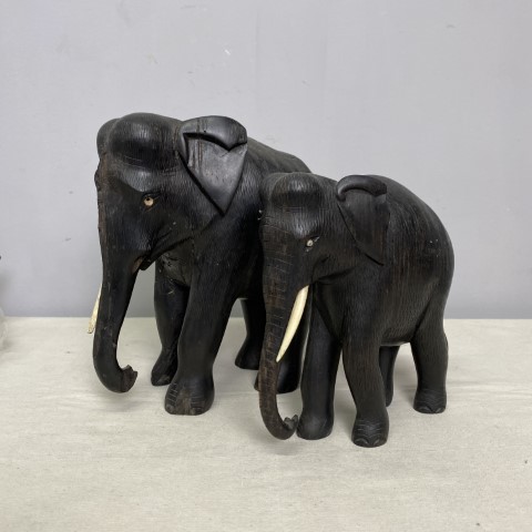 A pair of black carved timber elephants - one large and one small