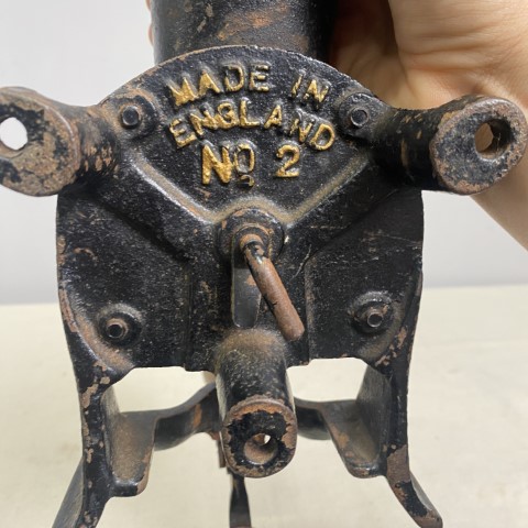 A vintage black cast iron meat grinder