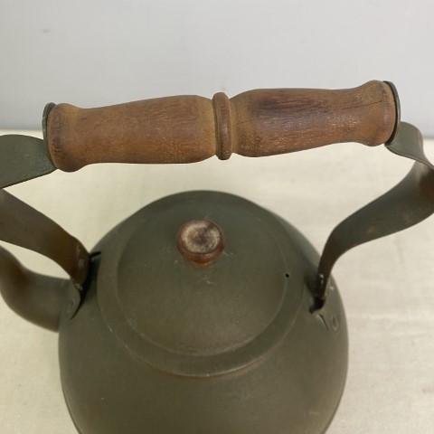 A vintage copper kettle with timber handle