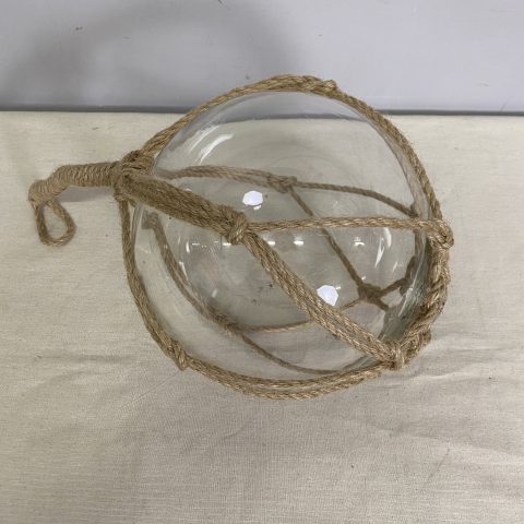 Coastal clear glass buoy wrapped in rope
